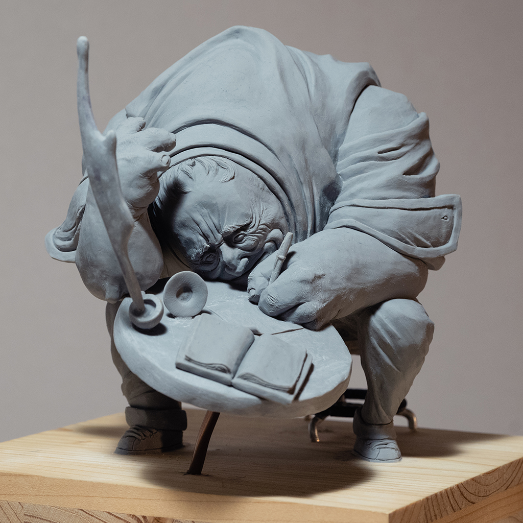 Sculpture de l'artiste Teddy Ros "café-créa" 2022, sculpté en pâte polymère , représentant un gros personnage assis sur un tabouret en train d'écrire dans son petit carnet, alors que sa tasse de café vol en éclat image 3