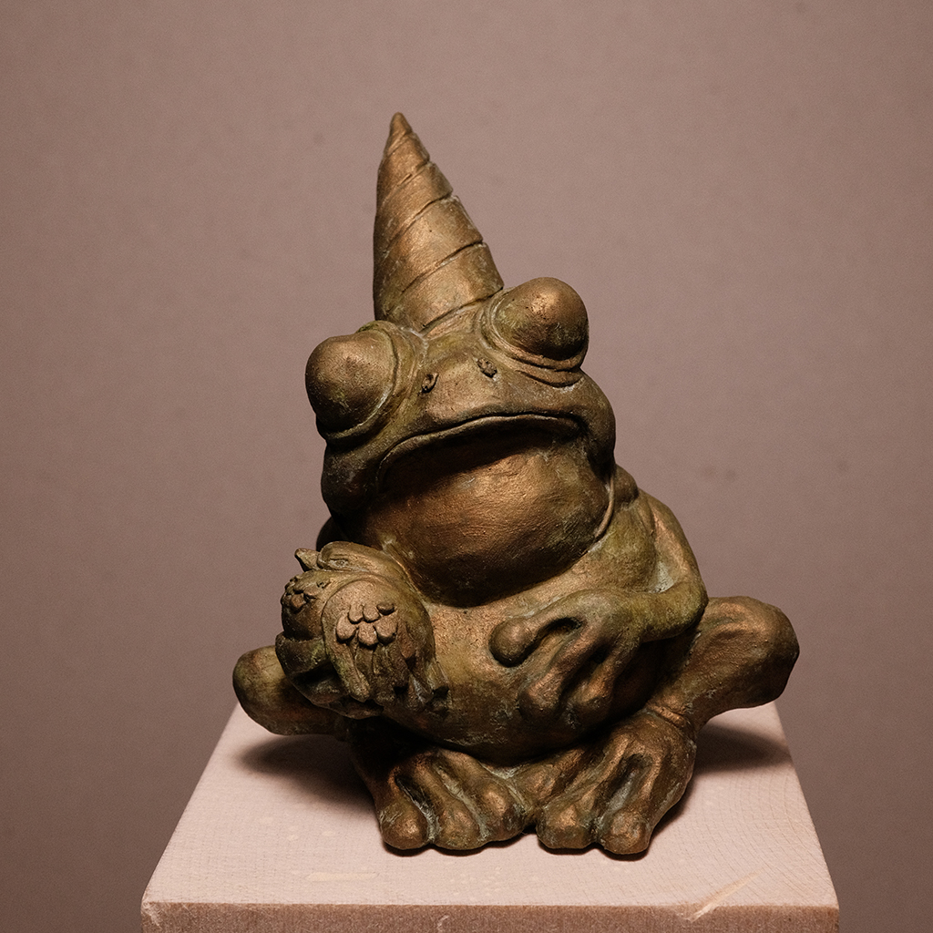 photo of details of the sculpture "Fête des toads" 2023 polymer clay version resin patinated green gold, made by the artist Teddy Ros representing a frog with a bird, image 01