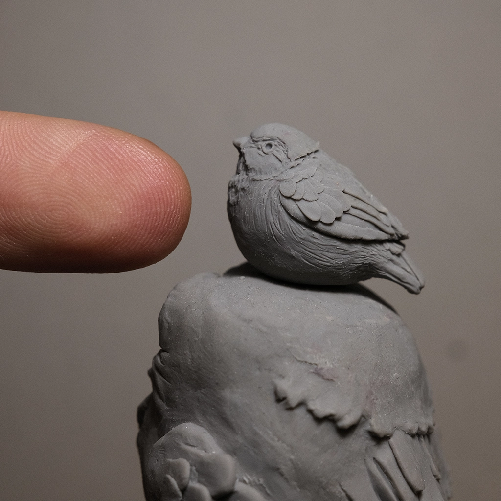 photo of details of the sculpture "Mr birds" 2023 polymer clay original version, made by the artist Teddy Ros representing two birds one on top of the other detail